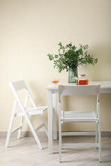 White kitchen table with tea and plant in bright room