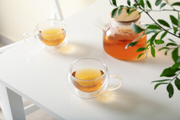 White kitchen table with tea and plant