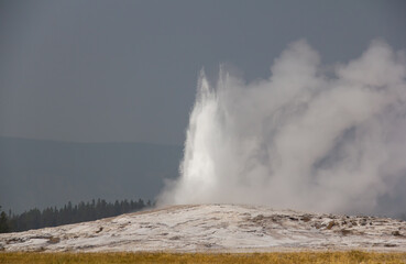 Old Faithful Yellowstone Park. Geyser in Wyoming.Geyser eruption. Cloudy.