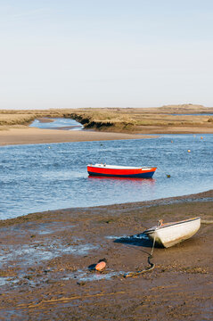Rowing boats at low tide. Burnham Overy Staithe, Norfolk, UK.