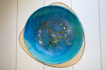 greek plate filled with herbs on a white table and floor lifestyle 