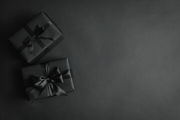 Gift boxes with black bows on black background