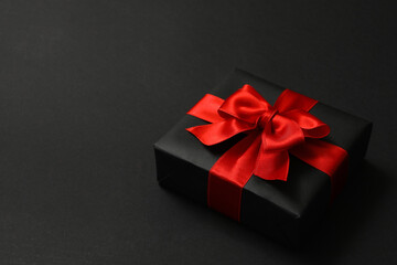 Gift box with red bow on black background