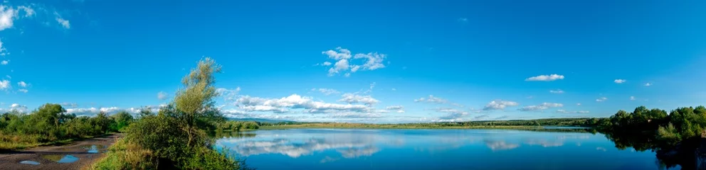Foto op Canvas Panoramic view of a calm lake on a sunny summer day © mikhailgrytsiv