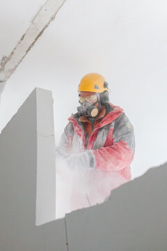 Construction worker demolishes interior wall