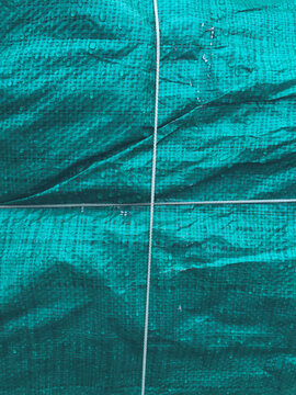 Rope covering green tarpaulin, close up