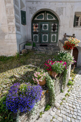 Naklejka premium Zugang mit Türe und Blumen eines Engadinerhaus, Guarda