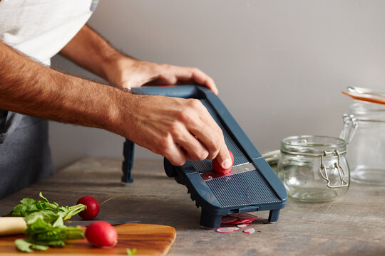 Man's hands grating radish