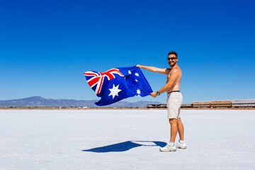 Man holds up the flag of Australia for Australia Day