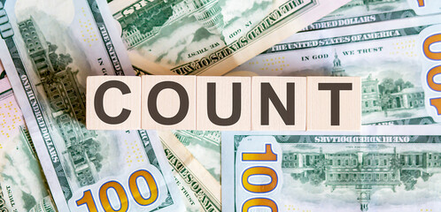 Concept words COUNT on wooden blocks on a beautiful background from dollar bills.