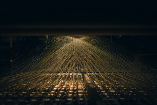 View of loom reels and illuminated threads stretching