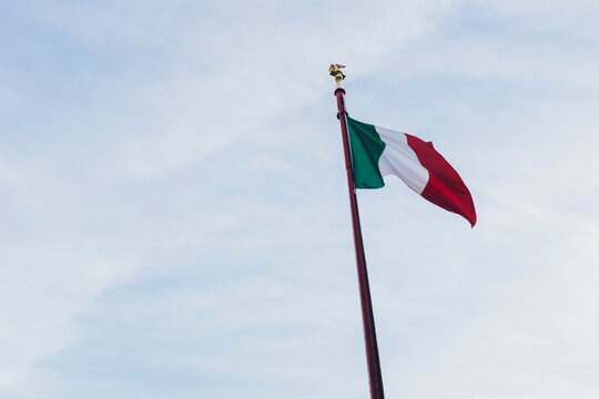 Italian flag weaving against of cloudy sky