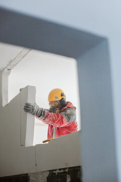 Construction worker demolishes interior wall