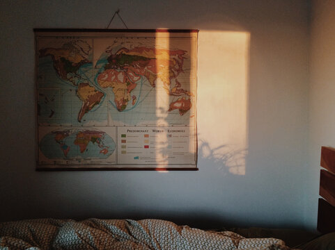 Dark bedroom with light reflecting on wall and map