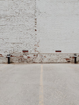 Old White Brick Building And Parking Lot