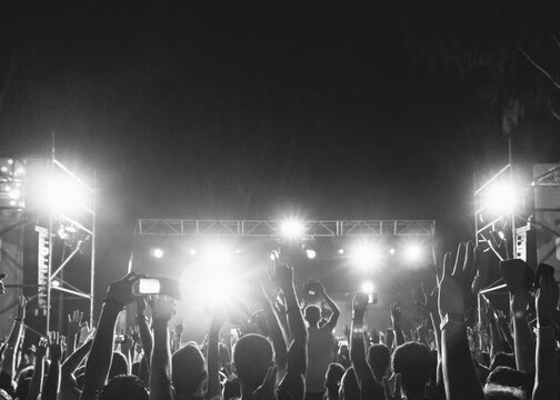 Silhouette of young people at a concert in the evening
