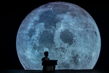 Silhouette of doll pianist playing against moon
