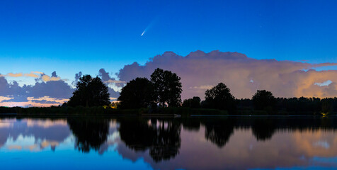 Meteor, shooting star or falling star seen in a night sky with clouds. Comet NEOWISE, C/2020 F3