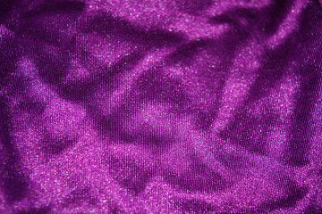 Obraz na płótnie Canvas Bright colorful, rich velvet purple background with overflow and ebb. An unusual shaggy purple fabric with curves and waves is located on a flat surface, an unusual look.