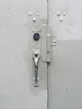 Detail of industrial warehouse door, paint covering graffiti tags