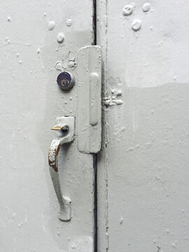 Detail of industrial warehouse door, paint covering graffiti tags