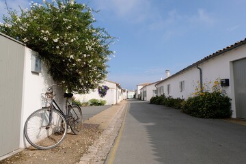 Vélo posé contre le mur d'une maison dans une rue de Loix sur l'île de Ré