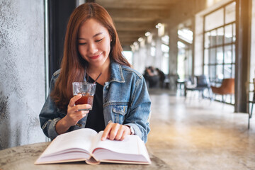 Portrait image of a young beautiful asian woman drinking coffee and reading book