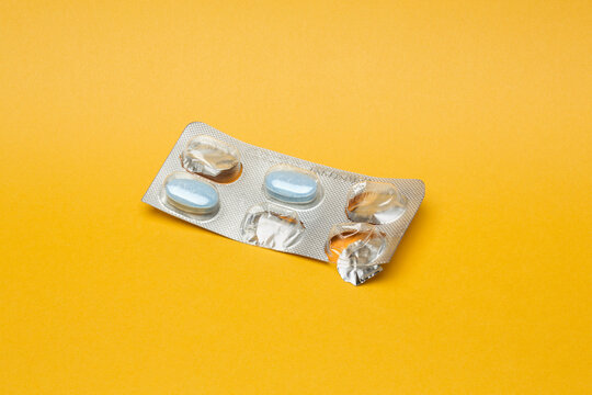 Blister pack of medicine with some pills missing shot on yellow background