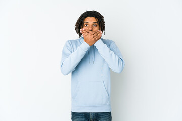 Young african american rasta man shocked covering mouth with hands.