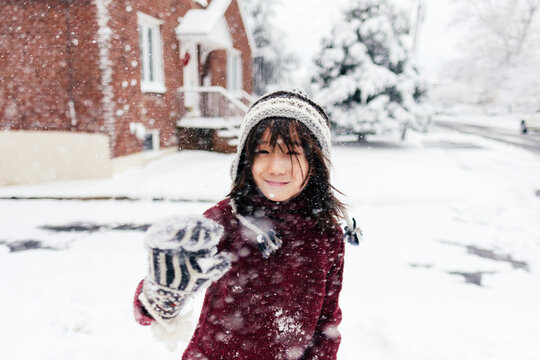 Young Mixed Race Boy Plays in Snow Outside