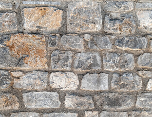 grey and brown stone wall closeup, rough pattern background