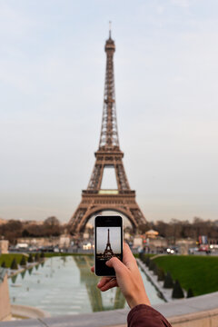 Woman taking photos with a smartphone to the Eiffel Tower, Paris