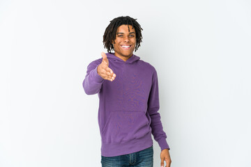 Young african american rasta man stretching hand at camera in greeting gesture.