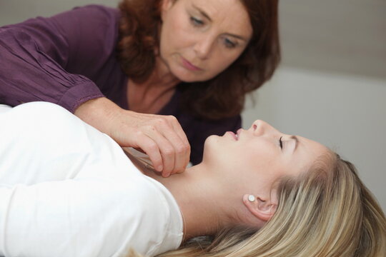 Body therapist touching patient's neck
