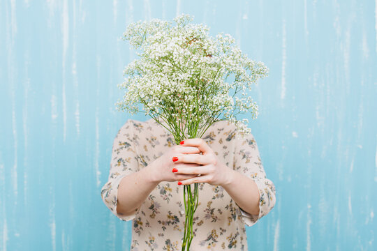 Woman hiding her face with Paniculata flowers.