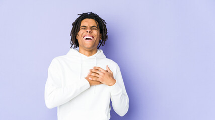 Young african american rasta man laughing keeping hands on heart, concept of happiness.