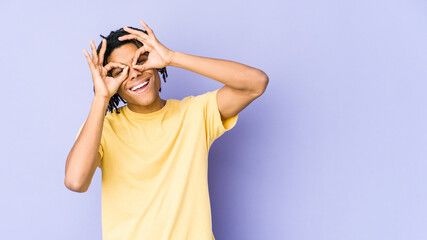 Young african american rasta man showing okay sign over eyes