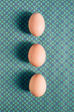 Three eggs on a green and blue pattern
