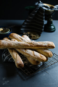 Freshly baked baguettes on a wire cooling rack.