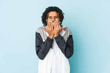 Young african american sport man laughing about something, covering mouth with hands.