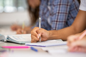 Student hand writing notes in classroom