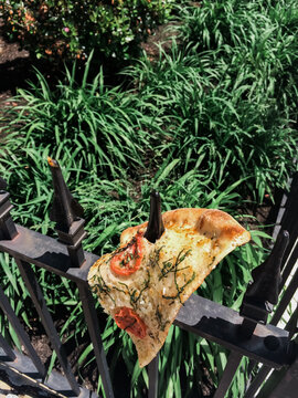 Margherita pizza impaled on iron fence