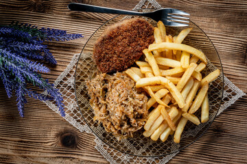 Pork chop in breadcrumbs served with fries and stewed cabbage.