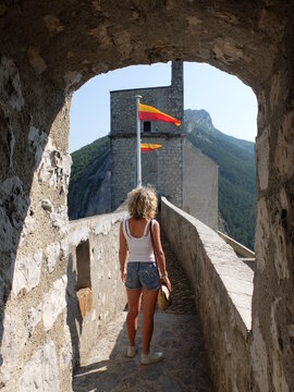 Jeune femme touriste qui visite un ch&acirc;teau avec drapeau et oriflamme