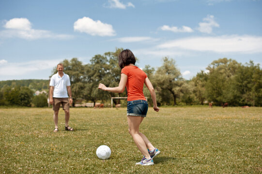 Young man and girl are playing soccer