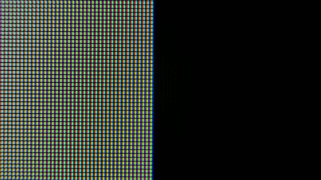 Pixels zoomed in with red, blue, and green glowing crystals and patterns on a computer graphics monitor. Pixels appear and then disappear on the screen.