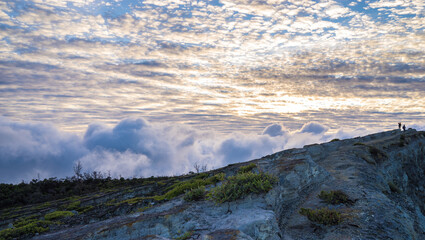 Beautiful sky with clouds in the morning, two trekkers on top of the hill, adventure travel concept, sunrise in the mountains