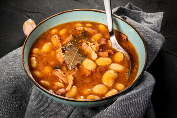Beans with tomato sauce, bacon and sausage.