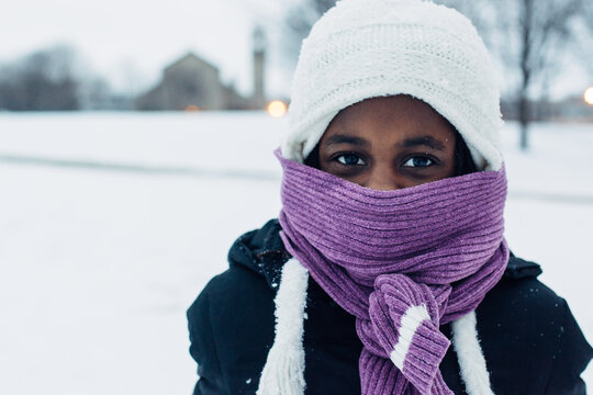 Bundled up black girl with purple scarf in the snow