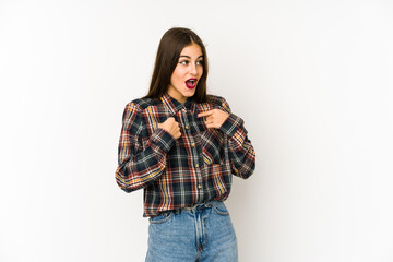 Young caucasian woman isolated on white background surprised pointing with finger, smiling broadly.
